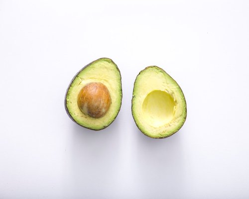 A perfectly halved avocado showing its creamy green flesh and pit